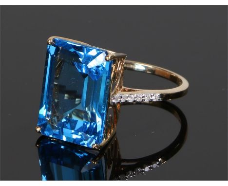 9 carat gold topaz set ring, the emerald cut blue topaz with six diamonds to either shoulder, ring size O