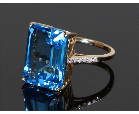 9 carat gold topaz set ring, the emerald cut blue topaz with six diamonds to either shoulder, ring size O