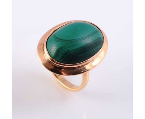 A MALACHITE AND GOLD RING
The oval cabochon cut malachite collet set in a raised slightly domed mount between simple closed s