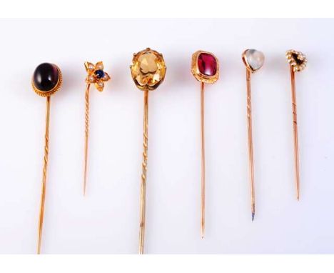 A COLLECTION OF SIX VICTORIAN MULTI GEM SET TIE PINS
To include a synthetic ruby, a heart cut moonstone, a citrine, an oval c