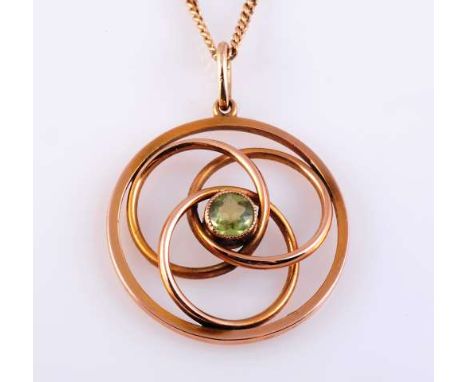 A PERIDOT AND GOLD PENDANT
c.1890
The round cut peridot millegrain set to the centre of three interlinked concentric circles,
