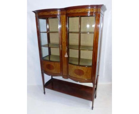 MAPLE & CO
AN EDWARDIAN INLAID MAHOGANY VITRINE
The double bow-front case with a pair of doors and inlaid with satinwood band