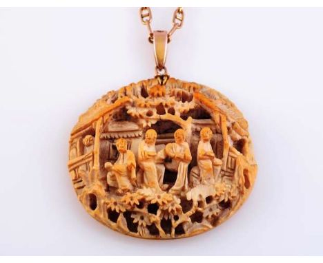 AN ORIENTAL CARVED IVORY PENDANT
Late 19th Century
The oval plaque with elaborate and intricate carving of five figures in a 