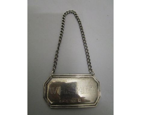 A mid 20th century Irish silver decanter label, rectangular with canted corners, reeded borders, engraved Whiskey, Dublin 196