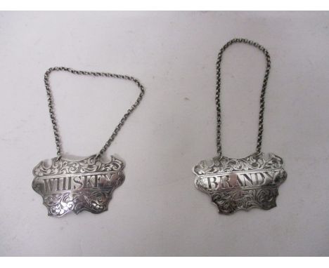 A pair of Victorian silver decanter labels, by George Unite, Birmingham 1843, engraved with scrolled foliage, 'Whiskey' and '