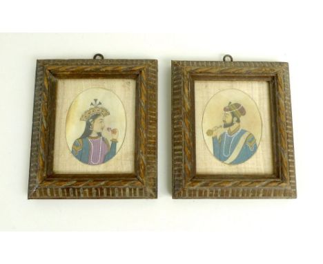 A pair of 19th century Indian or Asian oval portrait miniatures, she holding a flower, he a pipe, both in similar gilded garb