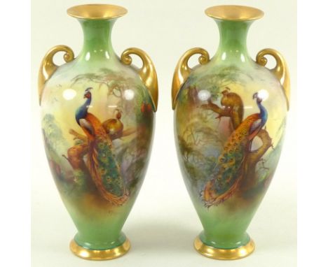 A pair of Royal Worcester vases, of twin handled baluster form, the flared neck with gilded inner, gilded scrolled handles an