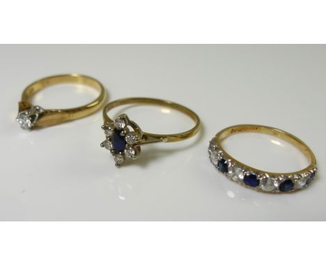 Three 9ct gold rings, one solitaire diamond set, 0.12ct, with leaf shoulders, size M, the second a daisy setting with central