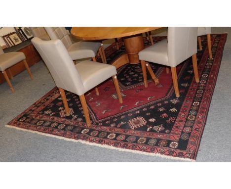 A West Iranian Village carpet, the strawberry field with latch hook medallion framed by triple borders, 303cm by 213cm