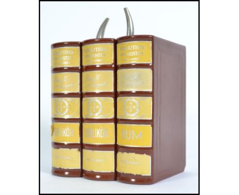 A set of 3 ceramic continental possibly German decanters with pourers for Rum &amp; Earlikor, all in the form of books. Measu