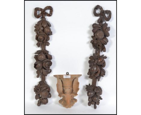 A carved Black Forest wall bracket in the form of a stag together with a pair of elaborate wall decoration carvings. The tall