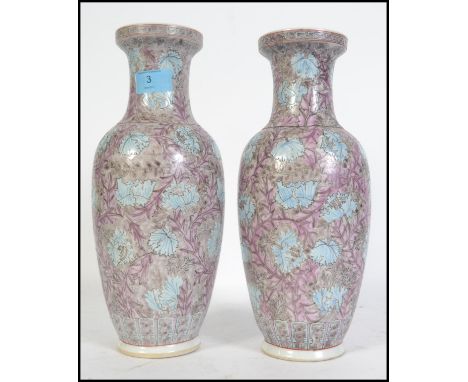 A pair of Chinese republic ceramic vases of famille rose design having purple and blue flower and vine decoration to the bulb