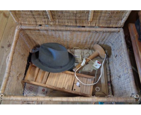 A wicker hamper containing a quantity of collectable items including wooden oversized domino set, a vintage fedora, etc.