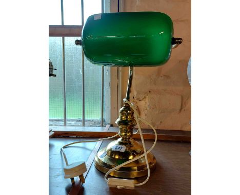 A modern brass banker's style lamp with green glass shade