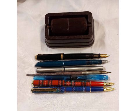 A bag containing a vintage Parker Duofold fountain pen and six other pens - sold with a Bakelite roller damper