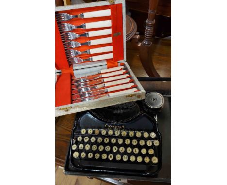 A vintage Corona portable typewriter in original hard carry case - sold with a cased set of fish knives and forks
