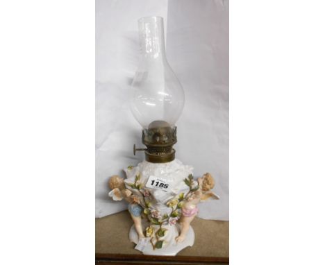A German porcelain oil lamp with cherub decoration