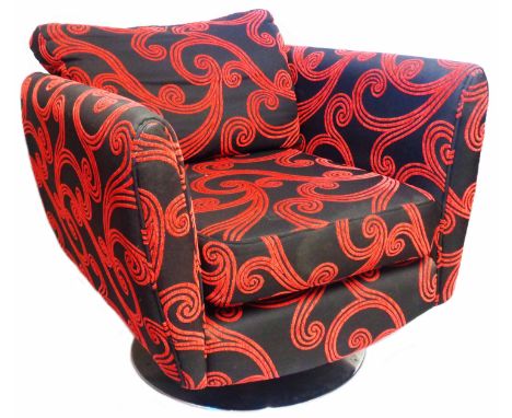 A modern retro style box frame armchair with black and red scroll machine tapestry upholstery, set on a metal swivel disc bas