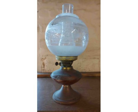 A vintage copper oil lamp with chimney and frosted and etched glass globe shade