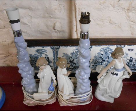 A pair of Nao porcelain figural table lamps and a similar figurine - all with original boxes