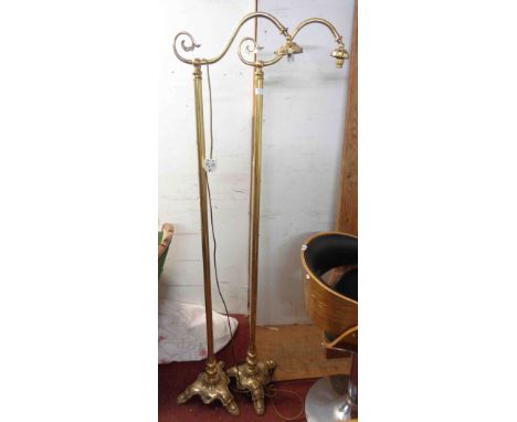 A pair of vintage brass standard lamps with scroll tops and slender pillars, set on cast trefoil bases