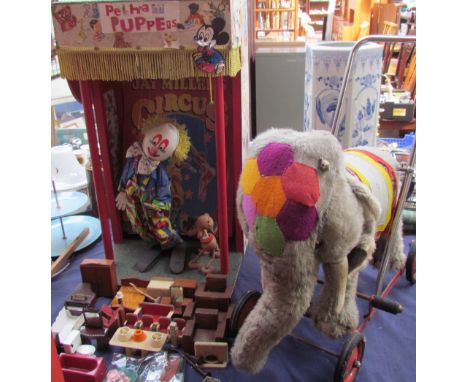 A puppet show together with assorted dolls furniture and a push along elephant