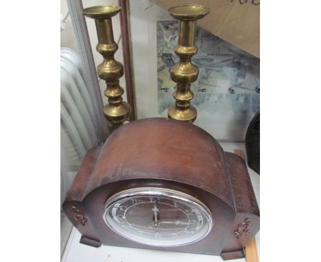 A large pair of brass candlesticks together with a mantle clock