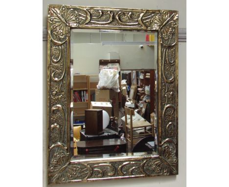 A brass framed wall mirror embossed with butterflies together with a copper bed warming pan