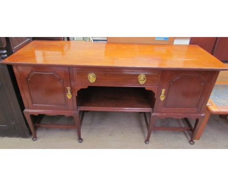 An early 20th century mahogany sideboard, the rectangular top above a central drawer and shelf flanked by cupboards, with Art