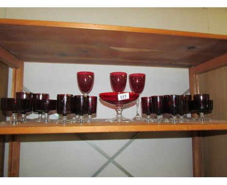 A shelf of red glass ware.