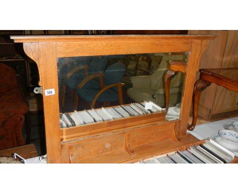 An oak overmantel mirror with shelf.