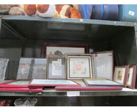 A shelf of framed and glazed prints.