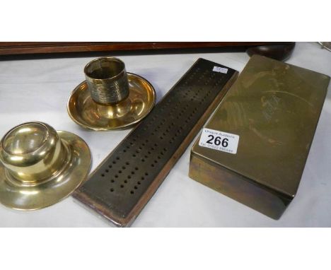 A brass cribbage board, brass inkwell, brass matchstriker and brass box.