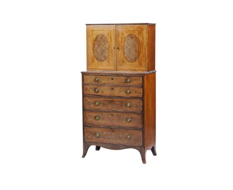 A George III mahogany secretaire cabinet on chest, the upper section with oval panel doors opening to reveal single adjustabl