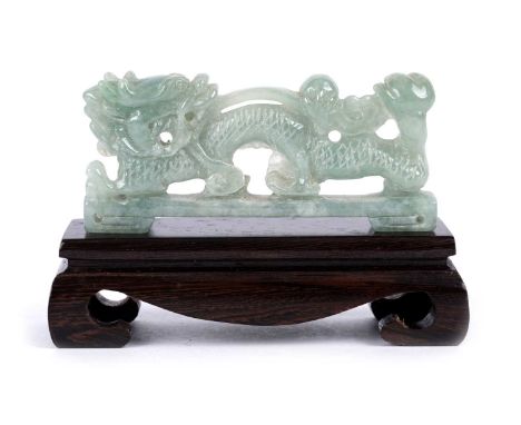 A Chinese carved pale green jade stylised dragon with lingzhi fungus, rectangular base, hardwood stand.