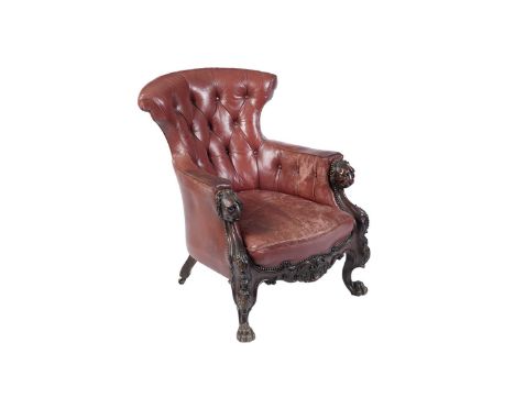 A Victorian carved oak button-back tub armchair, the red leather upholstered seat with a brass studded edge, the armrests wit