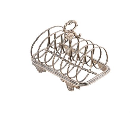 A GEORGE IV SILVER SIX DIVISION TOAST RACK MAKER'S MARK OBSCURED, LONDON 1829 With a foliate loop handle and on four scroll f