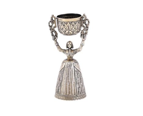 
	
		A SILVER GILT WAGER CUP
		BIRCH &amp; GAYDON, LONDON 1936
		Modelled as a lady holding aloft a swing cup
		13.5cm (5 1/4