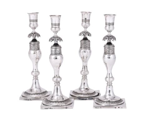 
	
		A SET OF FOUR GERMAN SILVER CANDLESTICKS
		GEBRUEDER GERIKE, CIRCA 1820
		With vase shaped capitals, foliate knopped bal