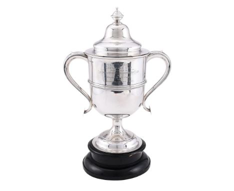 
	
		A SILVER TWIN HANDLED TROPHY CUP AND COVER
		WALKER &amp; HALL, SHEFFIELD 1920
		With an urn shaped finial to the ogee d
