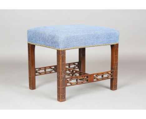 A George III Chinese Chippendale style mahogany stool, the overstuffed blue fabric seat on blind fretwork legs and pierced st