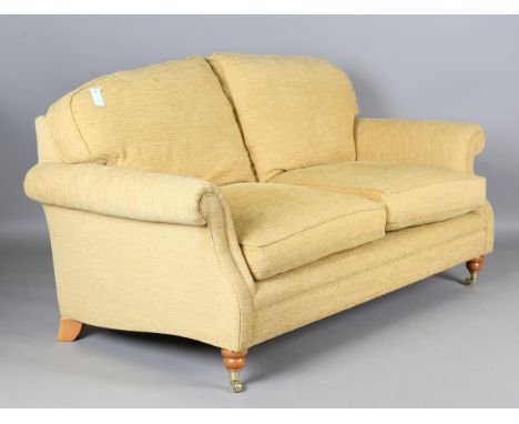 A Laura Ashley two-seat sofa, upholstered in yellow fabric, height 80cm, width 183cm, depth 95cm.Buyer’s Premium 29.4% (inclu