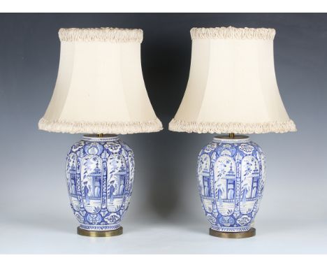 A pair of 20th century Dutch Delft blue and white table lamp bases, the shaped ovoid bodies decorated with reserve panels of 