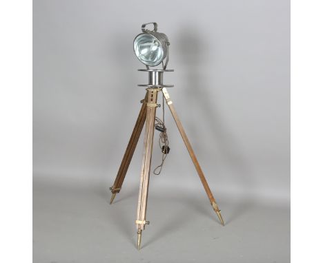A mid-20th century patinated tin studio floor lamp, one side support detailed 'KNPS 55', raised on an adjustable tripod, heig