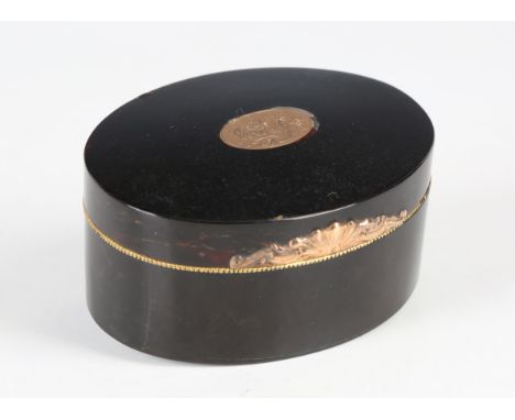 An early 19th century tortoiseshell oval table snuff box, the hinged lid and base with an inlaid foliate engraved gold reserv