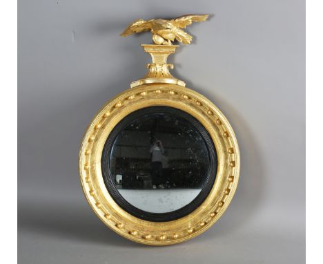 A Regency giltwood and gesso convex wall mirror with carved eagle surmount and ballshot mounted frame, height 83cm, width 57c