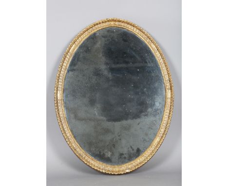 A George III giltwood oval wall mirror with a fluted and gadrooned frame, bordering a Vauxhall glass, 85cm x 65cm. Provenance