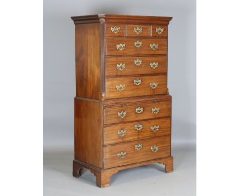 A George III mahogany chest-on-chest, fitted with an arrangement of oak-lined drawers and a brushing slide with original bras