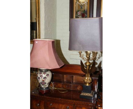 Ornate gilt metal eagle column table lamp and pottery table lamp with shade.