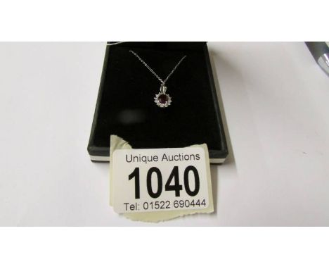 An 18ct white gold ruby and diamond pendant necklace, 90 points, cased.